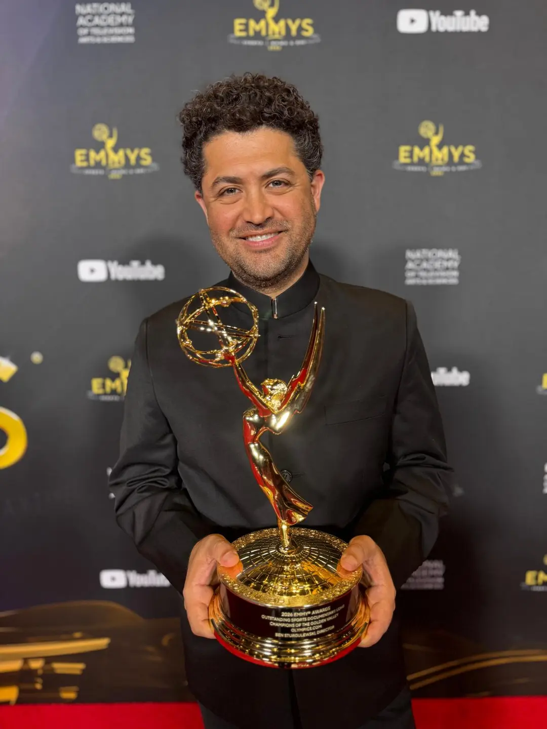 Baktash Ahadi holding an Emmy statuette.