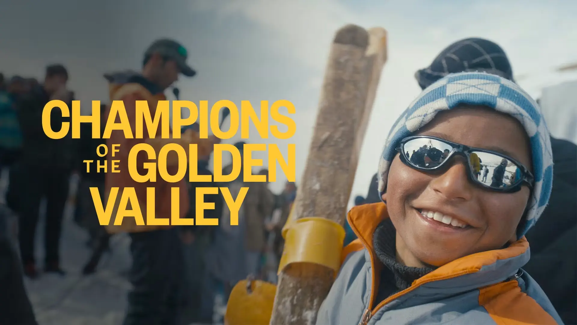 A young skier in sunglasses and a striped hat grins at the camera in Bamyan; the film title Champions of the Golden Valley beside him.